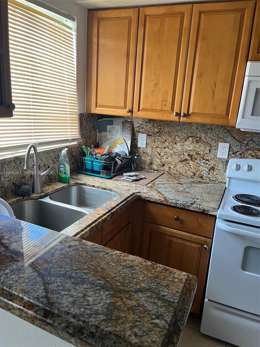 403 Northwest 84th Street, Unit 403 Miami, FL 33150 - Photo 1 of 5 a kitchen with a sink stove and cabinets