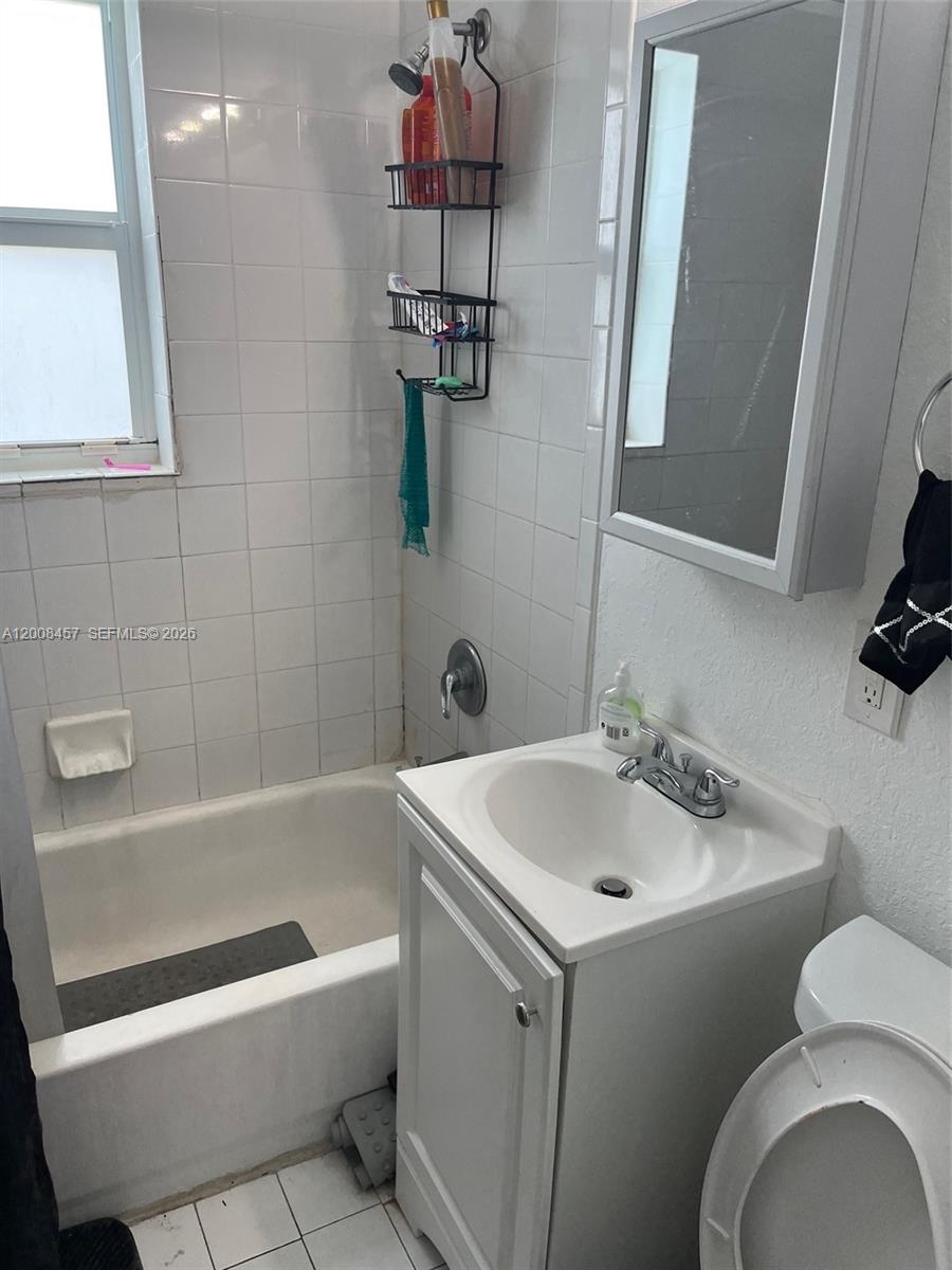 403 Northwest 84th Street, Unit 403 Miami, FL 33150 - Photo 4 of 5 a bathroom with a sink a toilet and bathtub