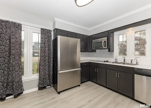 a kitchen with stainless steel appliances granite countertop a refrigerator and a sink