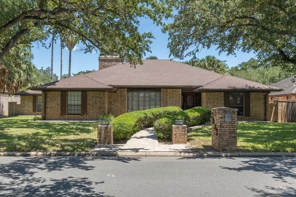 a front view of a house with a yard and trees