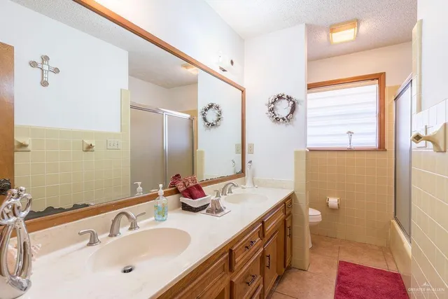 a bathroom with a double vanity sink mirror and shower