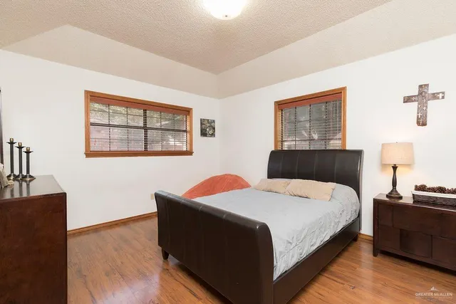 a bedroom with a bed and wooden floor