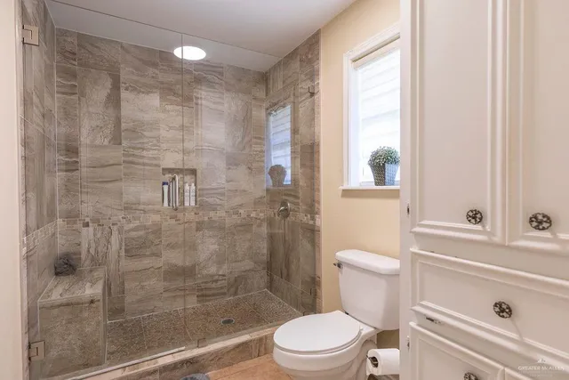 a bathroom with a shower a toilet and a sink