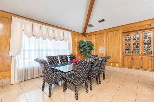 a dining room with furniture and large windows