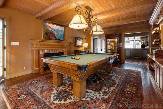 a room with pool table and wooden floor