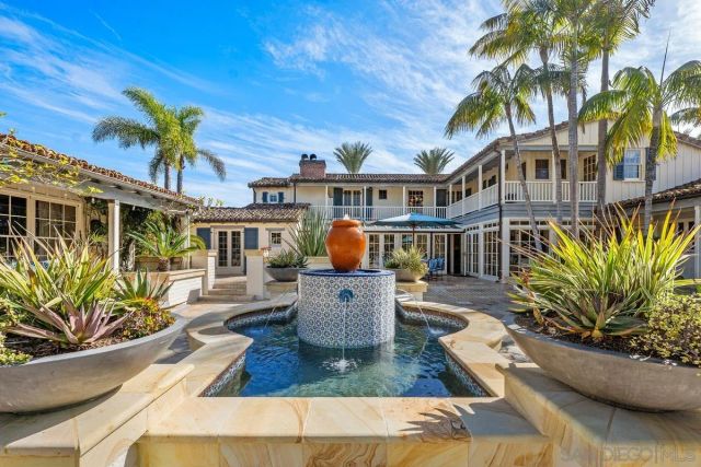 a view of a house with backyard water fountain and sitting area