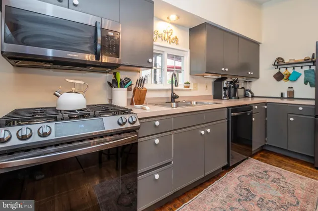 a kitchen with stainless steel appliances granite countertop sink stove and cabinets