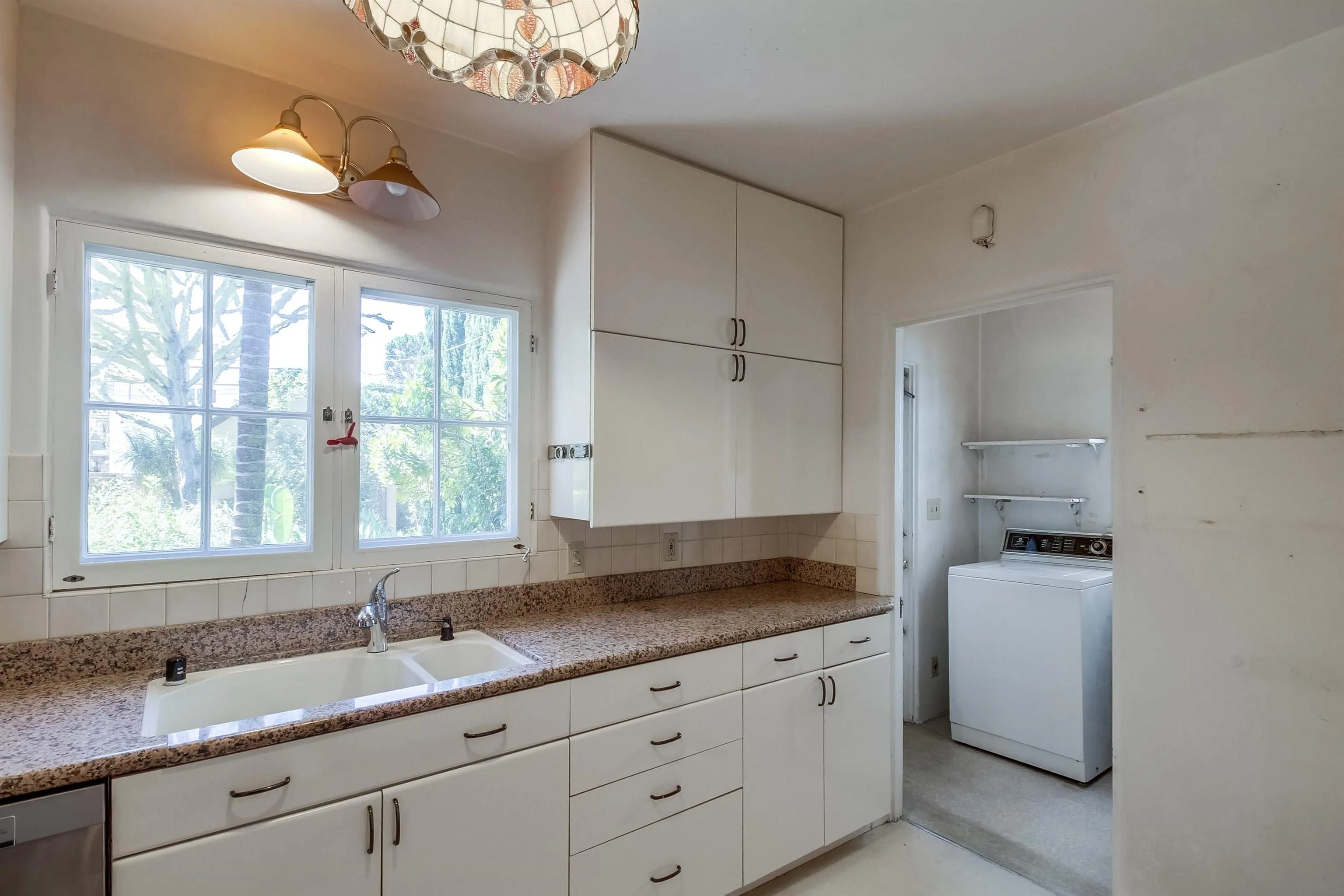 340 B Avenue Coronado, CA 92118 - Photo 9 of 31 a kitchen with granite countertop a sink a window and stainless steel appliances