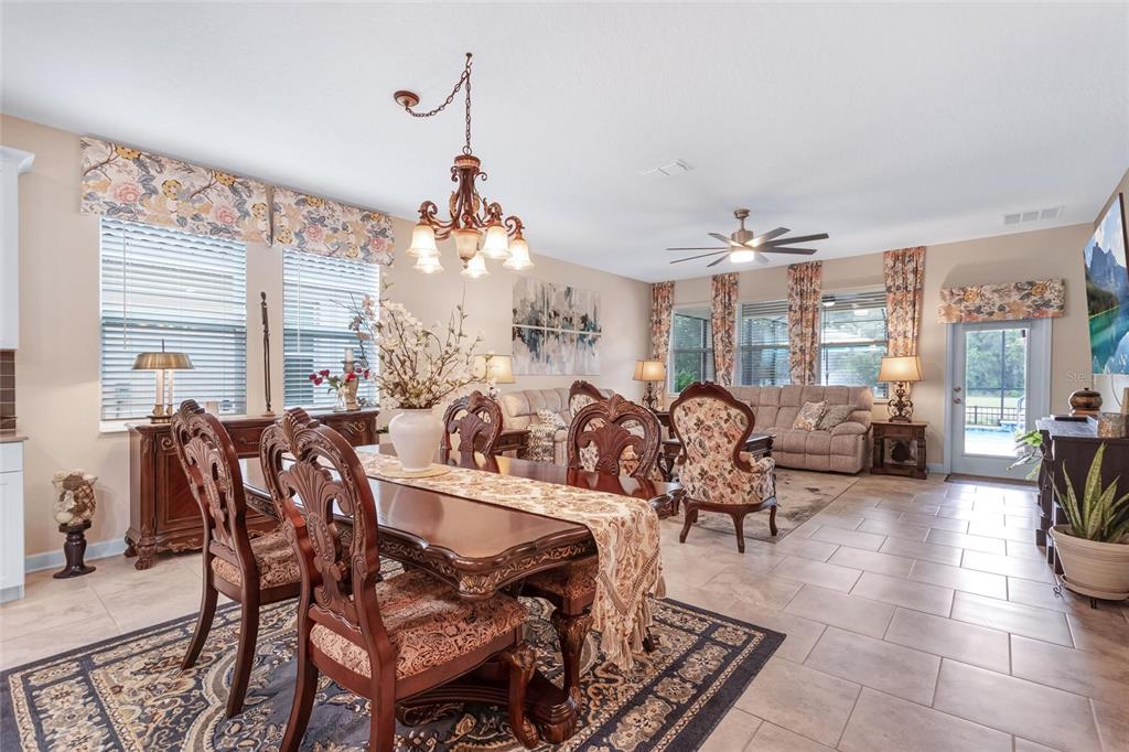 1089 Blackwolf Run Road Davenport, FL 33896 - Photo 13 of 82 a living room with lots of furniture and a chandelier