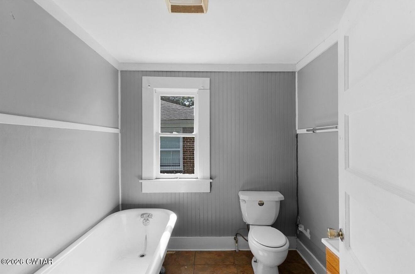 125 Williams Street Jackson, TN 38301 - Photo 16 of 17 a bathroom with a toilet a sink and a window