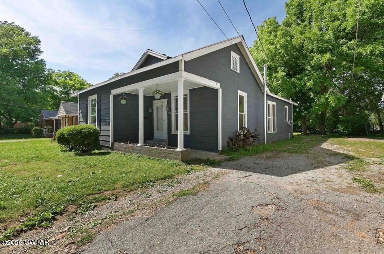 125 Williams Street Jackson, TN 38301 - Photo 2 of 17 a view of a small house in front of a house with plants and large tree