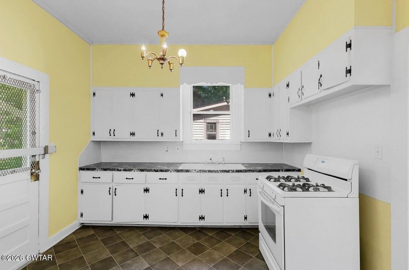 125 Williams Street Jackson, TN 38301 - Photo 10 of 17 a kitchen with granite countertop a white cabinets and a stove