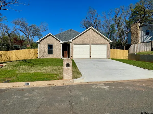 a view of a house with a yard and large tree