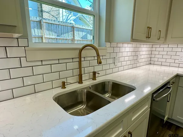 a kitchen with kitchen island a counter top space a sink stainless steel appliances and cabinets
