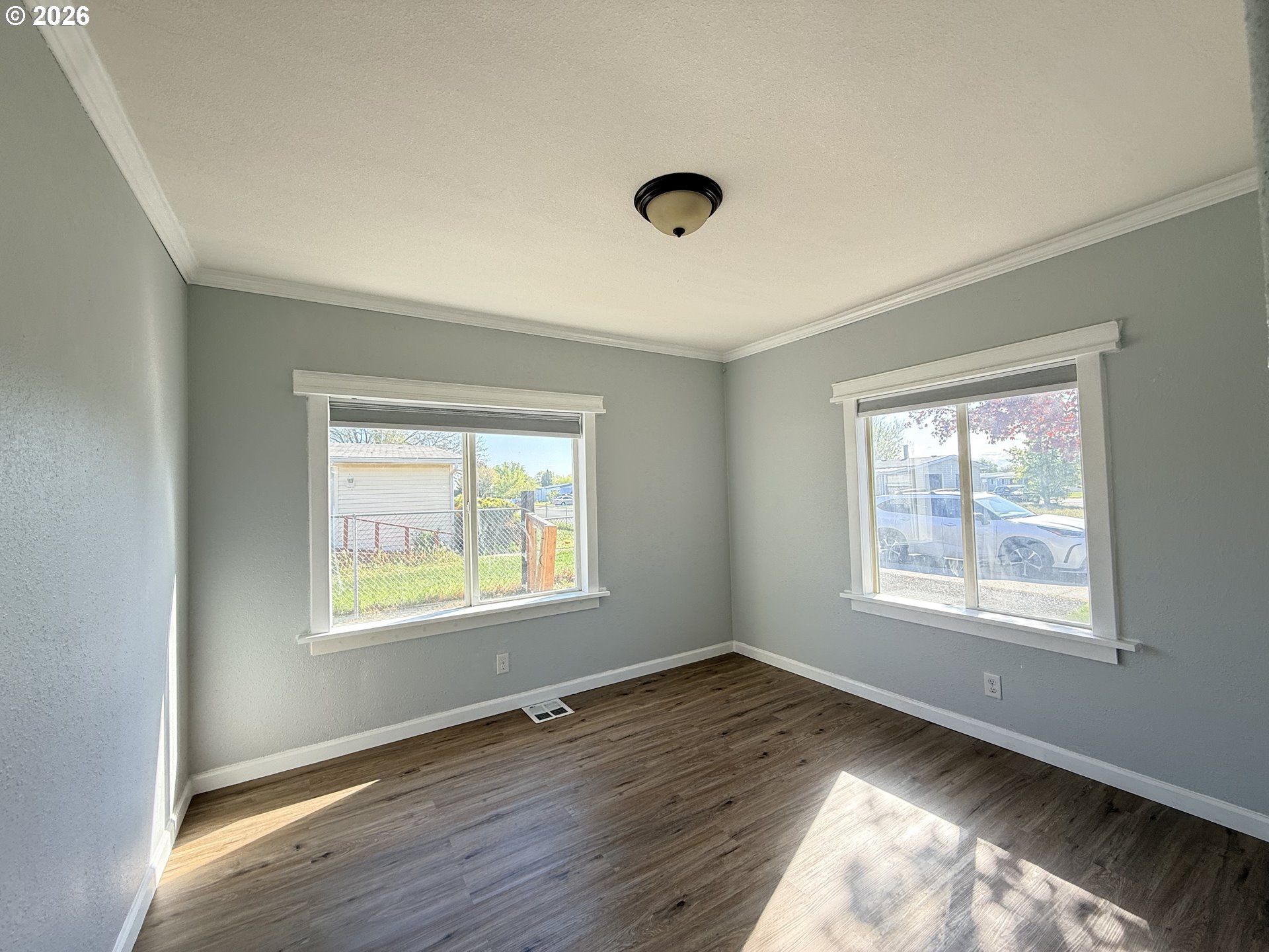 1330 West Sunland Avenue Hermiston, OR 97838 - Photo 10 of 23 a view of an empty room with wooden floor and a window