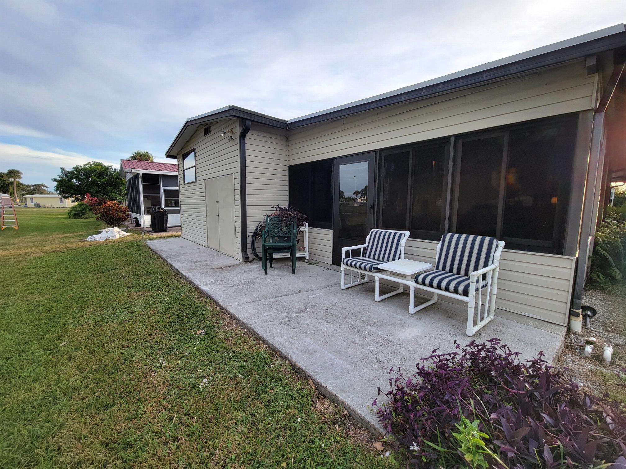 13690 Northwest 127th Terrace Okeechobee, FL 34974 - Photo 23 of 23 a view of a chair and table in backyard of the house