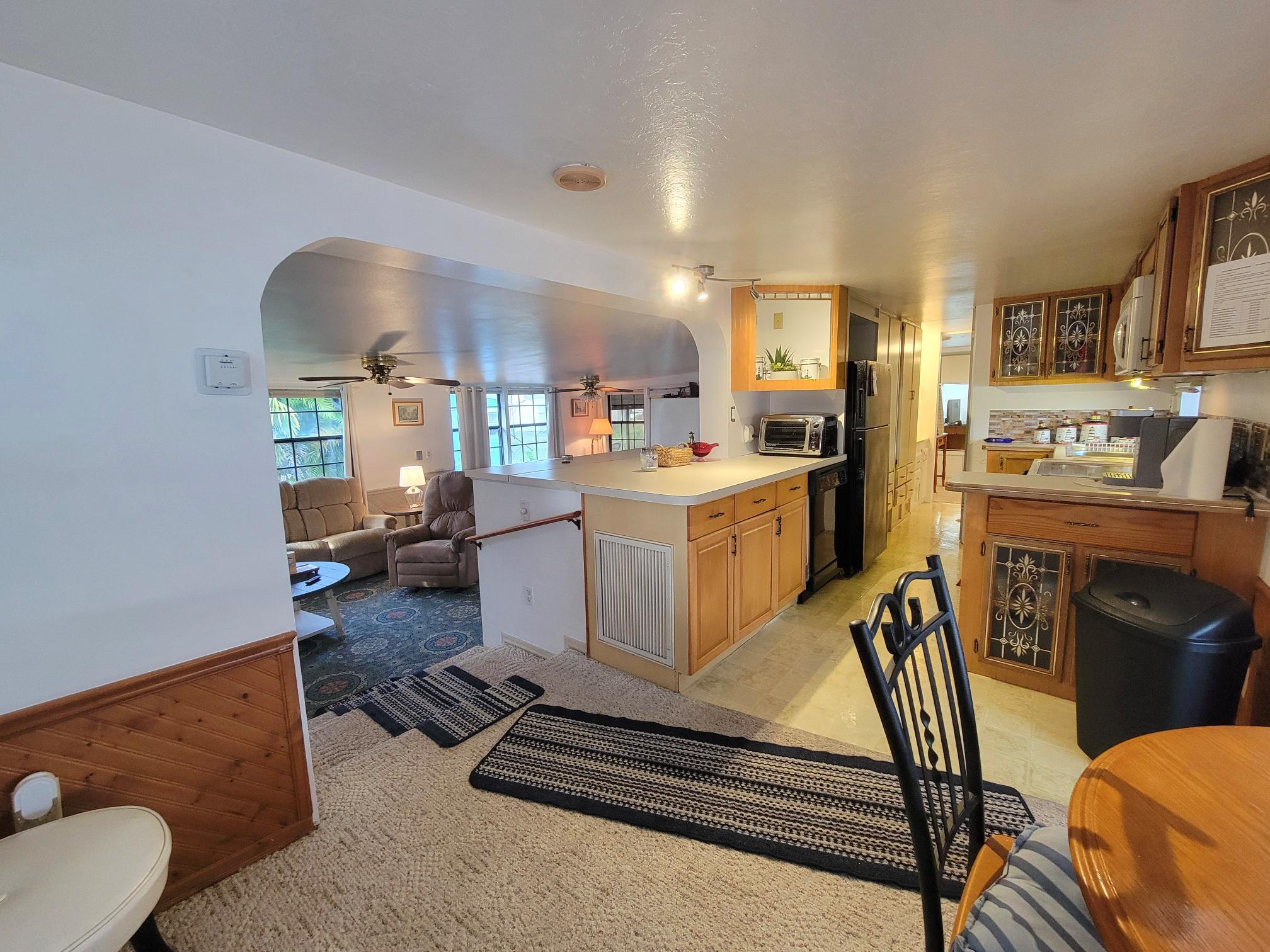 13690 Northwest 127th Terrace Okeechobee, FL 34974 - Photo 10 of 23 a living room with furniture a rug kitchen view and a fireplace