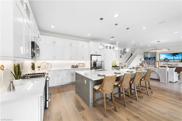 a kitchen with appliances a sink a counter top space and cabinets