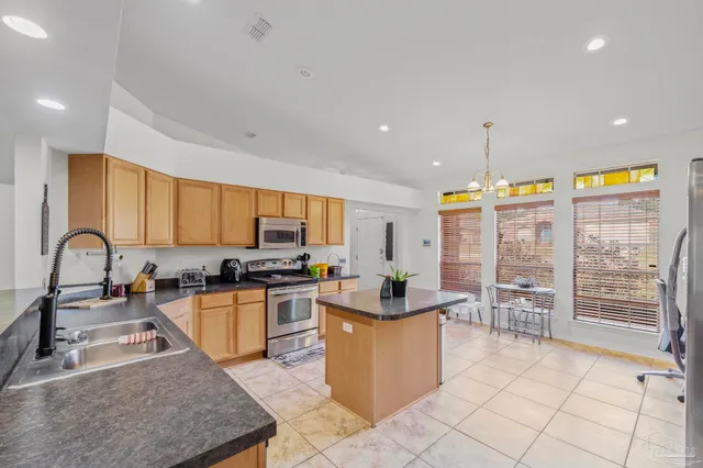 a kitchen with a large counter top space appliances and cabinets