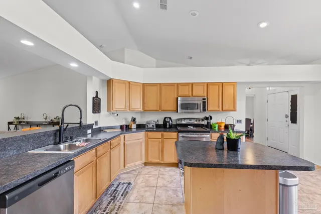a kitchen with counter top space cabinets and appliances