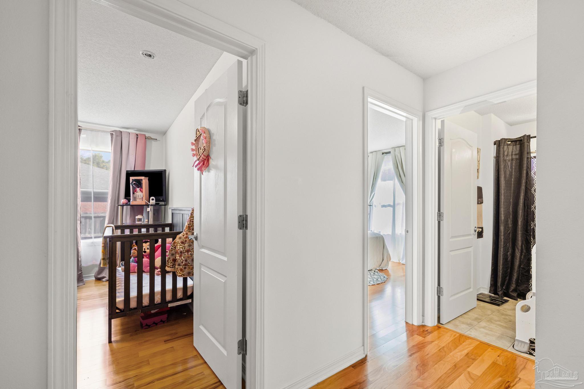 2165 Liberty Loop Road Cantonment, FL 32533 - Photo 29 of 51 a view of a hallway with bedroom and wooden floor