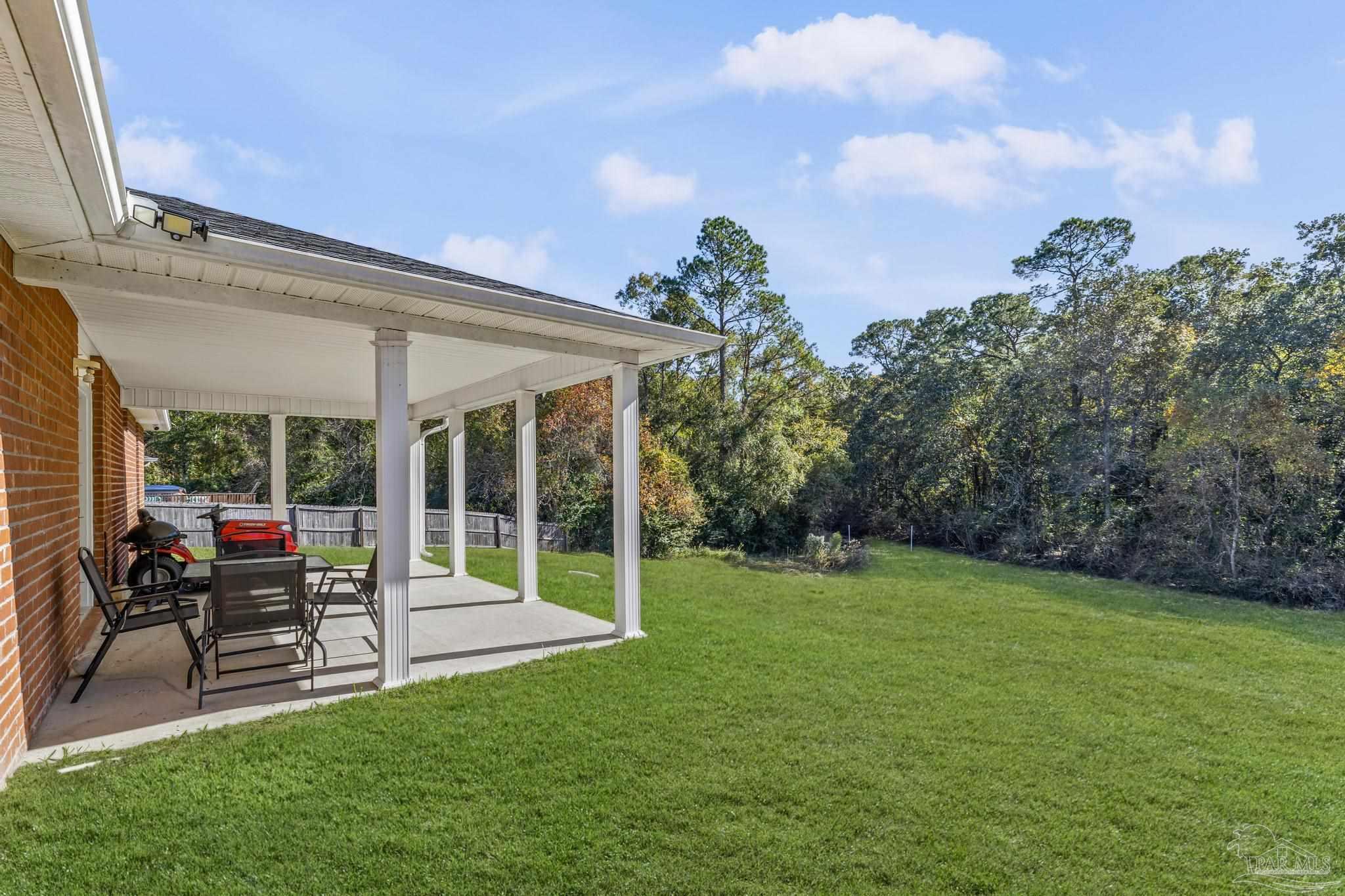 2165 Liberty Loop Road Cantonment, FL 32533 - Photo 32 of 51 a view of a house with a backyard porch and sitting area