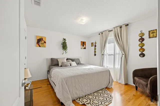a bedroom with a bed and a chair with the bookshelf