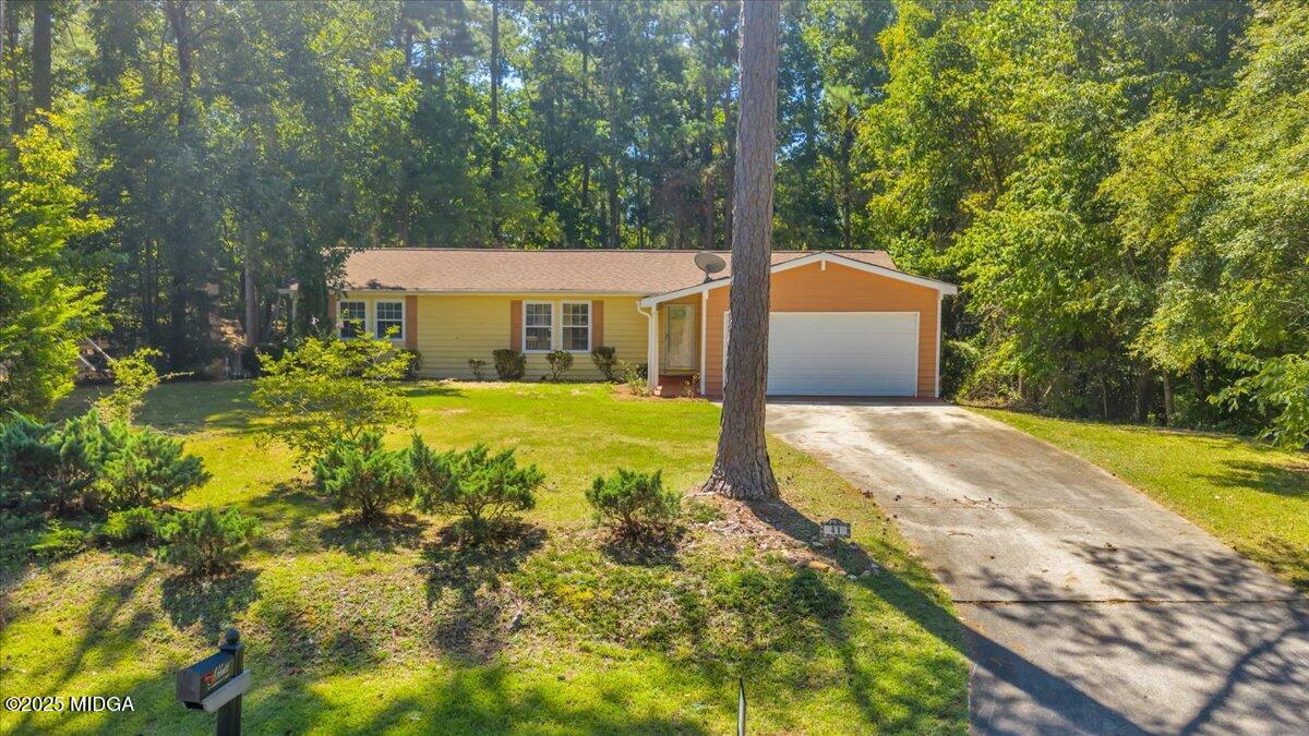 a front view of a house with a yard and large trees