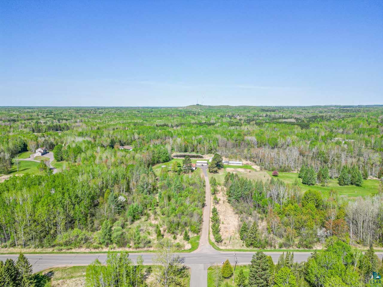 2581 O'Rourke Road Hibbing, MN 55746 - Photo 60 of 61 Expansive wooded landscape featuring a paved road intersection and a clear sky