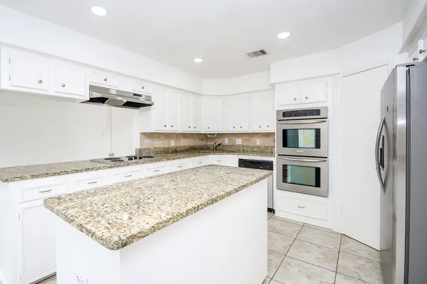a kitchen with stainless steel appliances granite countertop a sink stove and refrigerator