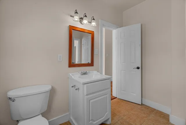 a bathroom with a toilet sink and mirror