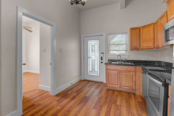 a kitchen with granite countertop wooden floors and stainless steel appliances