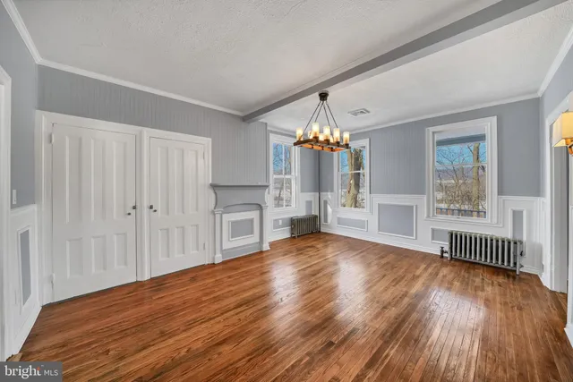 a view of empty room with wooden floor and fireplace