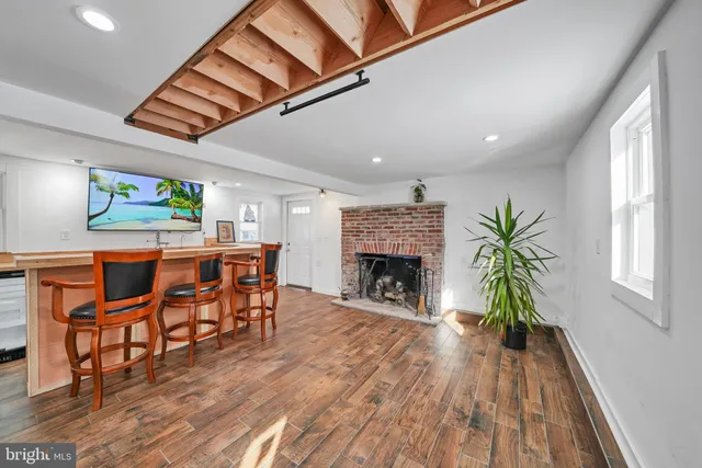 a living room with furniture a fireplace and a wooden floor