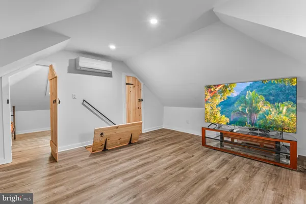 a view of an empty room with wooden floor and windows