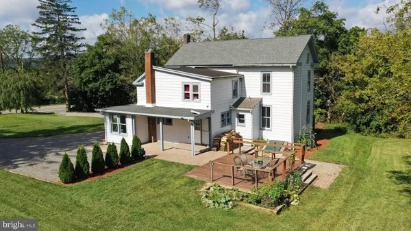 an aerial view of a house having patio with a garden