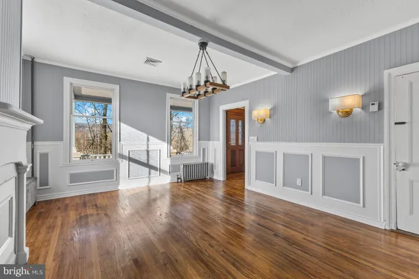 a view of a livingroom with an entryway and wooden floor