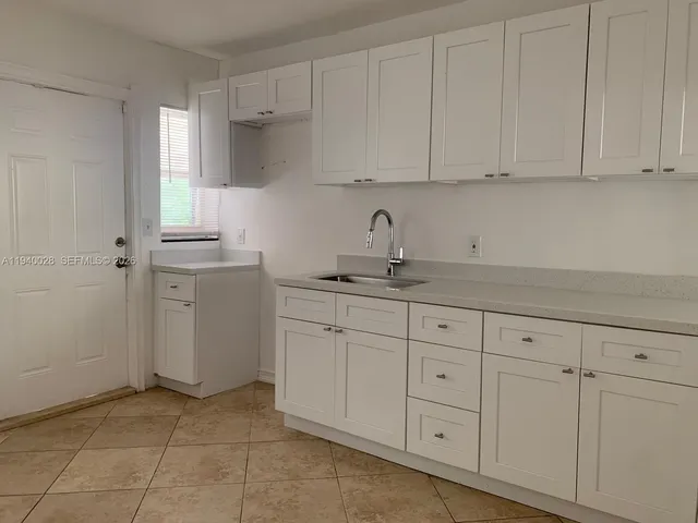 a kitchen with white cabinets and a sink