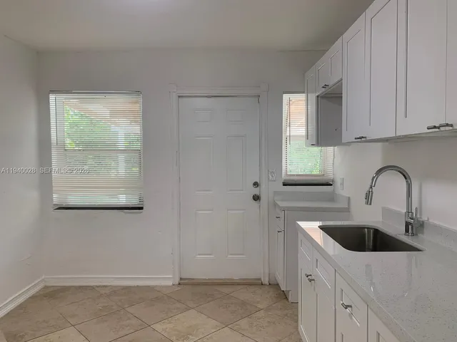 a kitchen with stainless steel appliances a sink a refrigerator and window