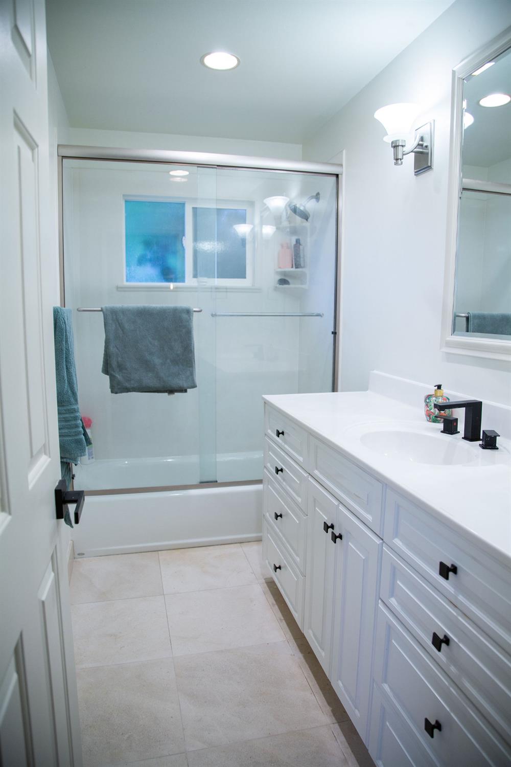 1208 Bristol Court Modesto, CA 95350 - Photo 22 of 40 bathroom #2 with vanity, enclosed tub / shower combo, recessed lighting, and light tile patterned floors