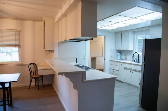 a kitchen with cabinets and chairs