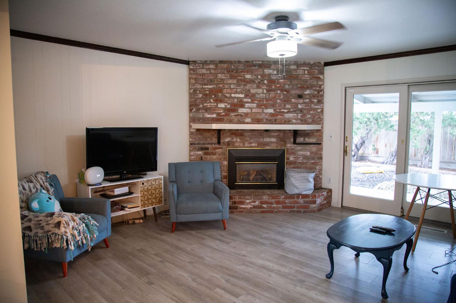 1208 Bristol Court Modesto, CA 95350 - Photo 7 of 40 living area featuring crown molding,, a brick fireplace, and a ceiling fan