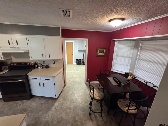 a view of kitchen with stainless steel appliances dining table and chair