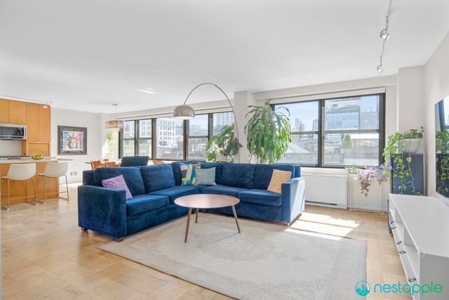 7 East 14th Street, Unit 1009 Manhattan, NY 10003 - Photo 5 of 13 a living room with furniture and a large window