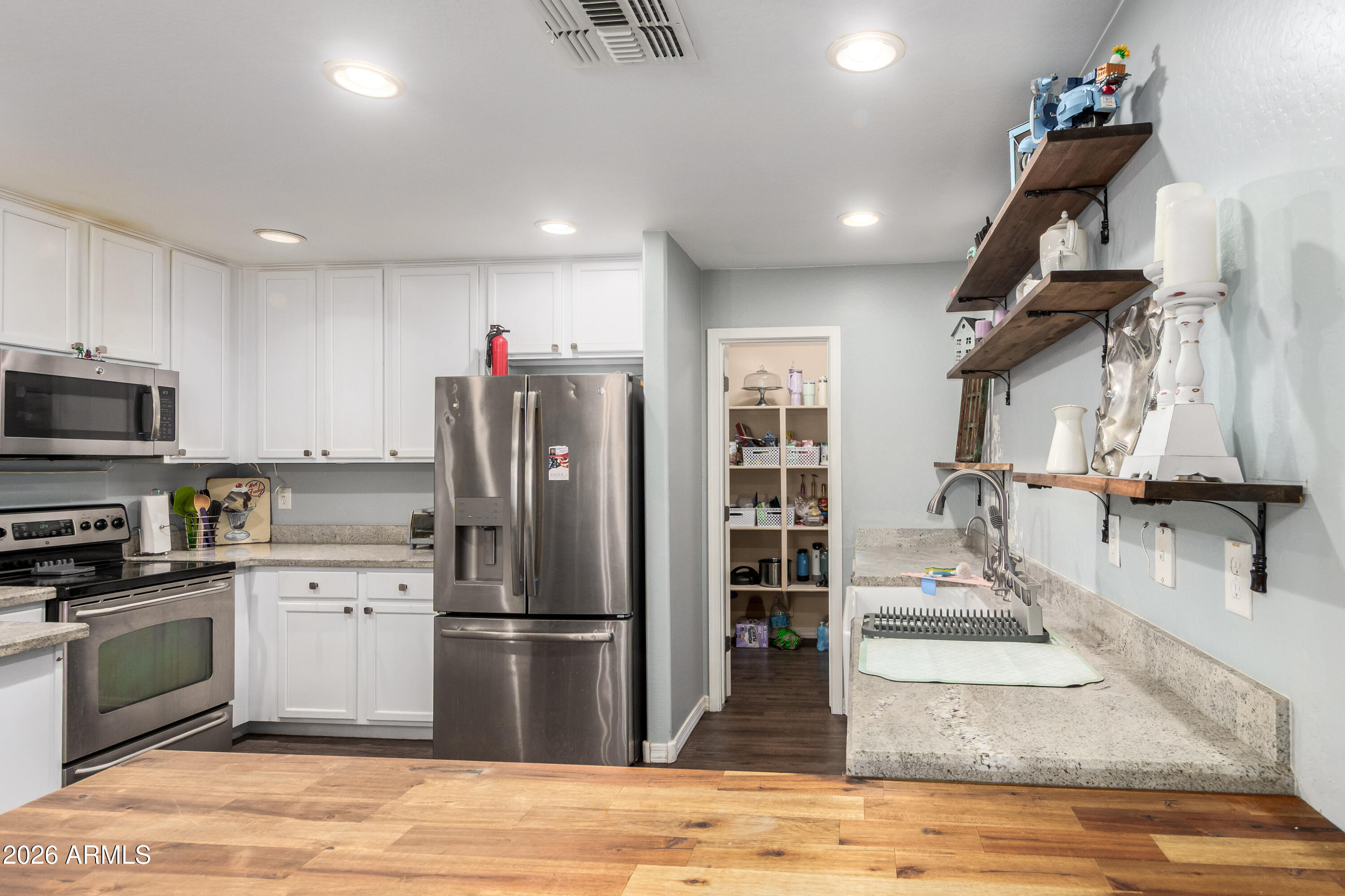 907 South Henry Lane Gilbert, AZ 85296 - Photo 8 of 25 a kitchen with stainless steel appliances granite countertop a refrigerator a stove and a sink