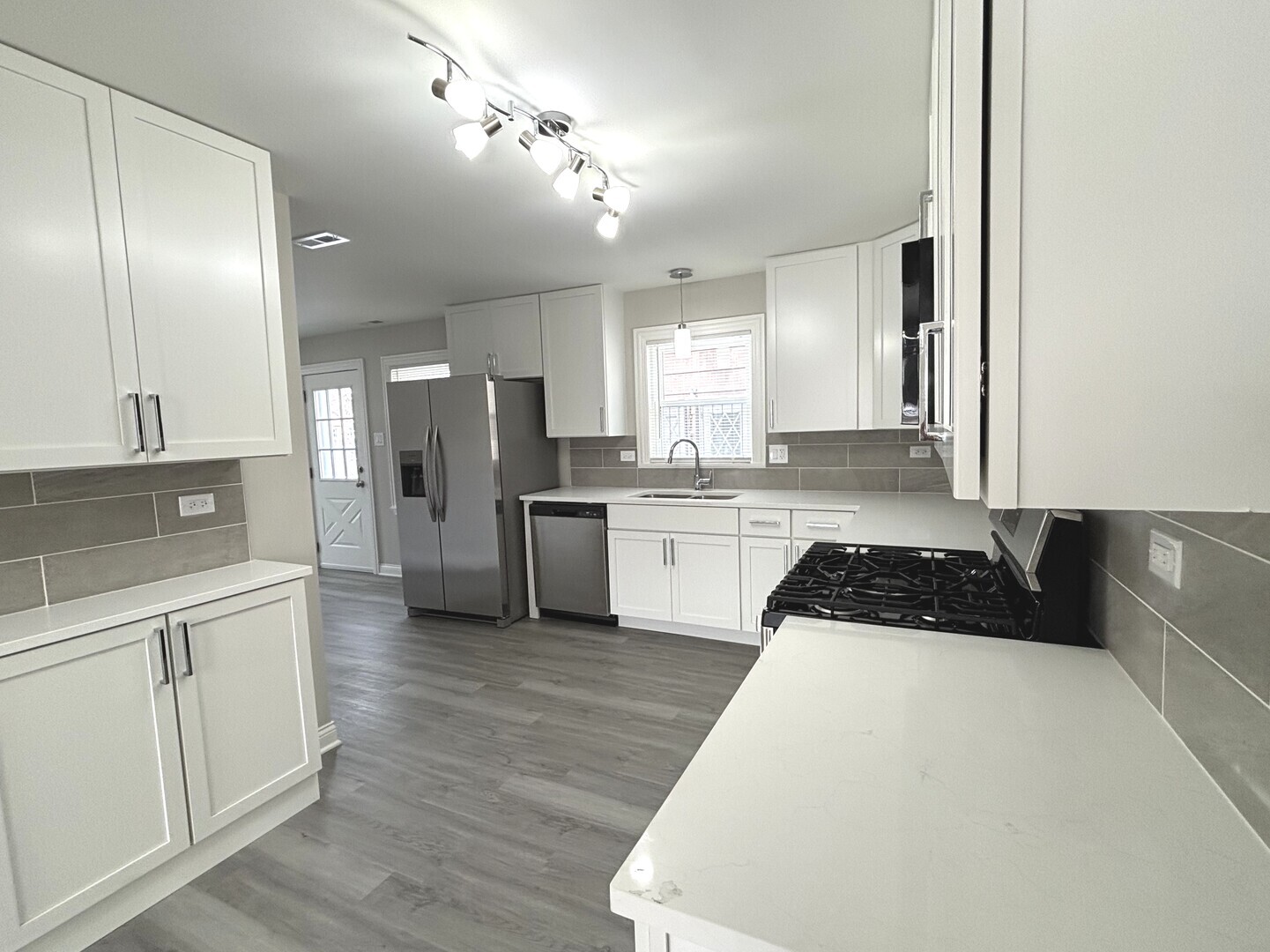 17092 Lincoln Street Hazel Crest, IL 60429 - Photo 8 of 20 a large kitchen with a refrigerator a sink dishwasher a stove and white cabinets with wooden floor