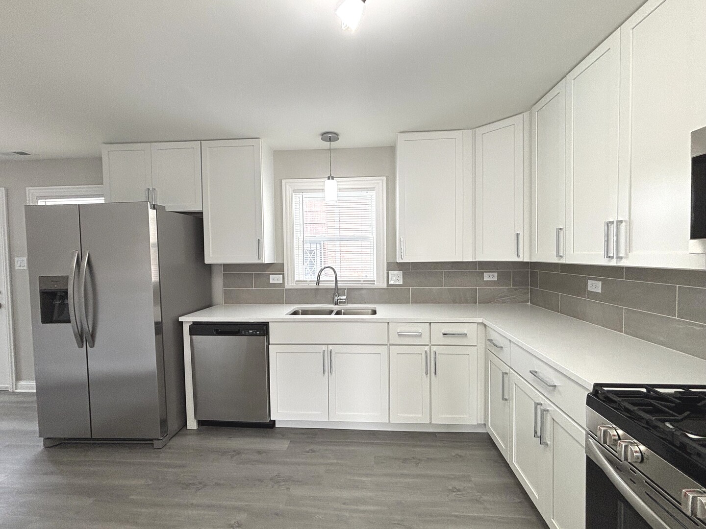 17092 Lincoln Street Hazel Crest, IL 60429 - Photo 9 of 20 a kitchen with white cabinets stainless steel appliances a sink and a window