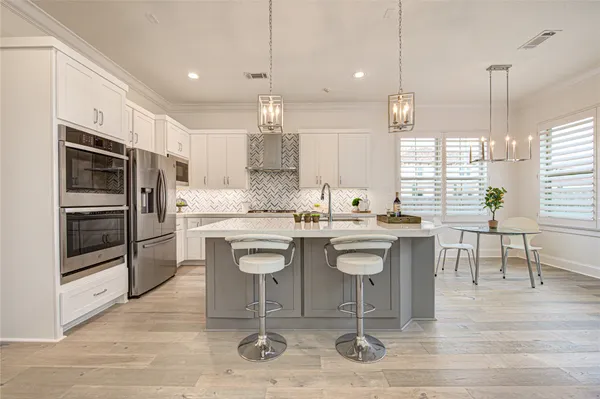 a kitchen with stainless steel appliances kitchen island granite countertop a sink and refrigerator