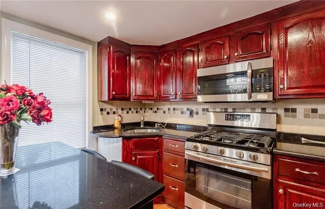 a kitchen with stainless steel appliances granite countertop a stove microwave and sink