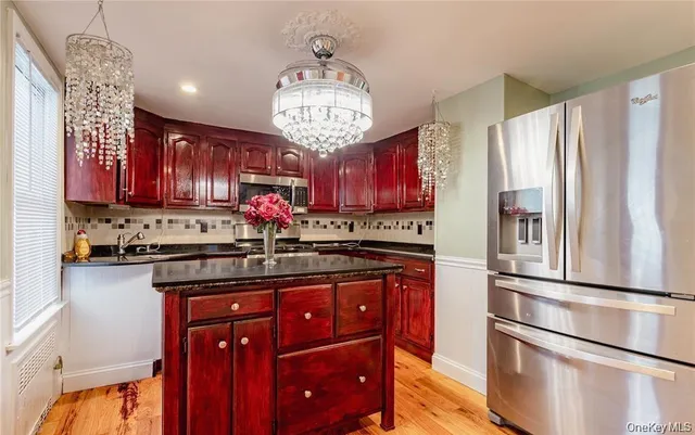 a kitchen with stainless steel appliances granite countertop a refrigerator and a stove